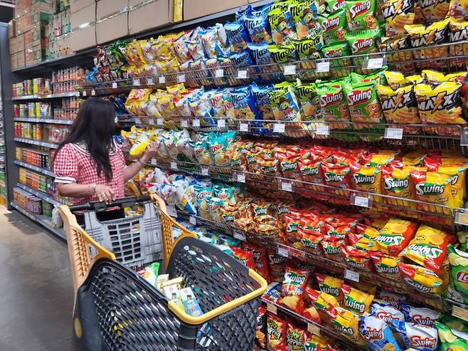 베트남 호치민에 위치한 이마트 고밥점에서 한 고객이 오리온 스낵 제품이 진열된 매대에서 제품을 살펴보고 있다./사진=차현아 기자.