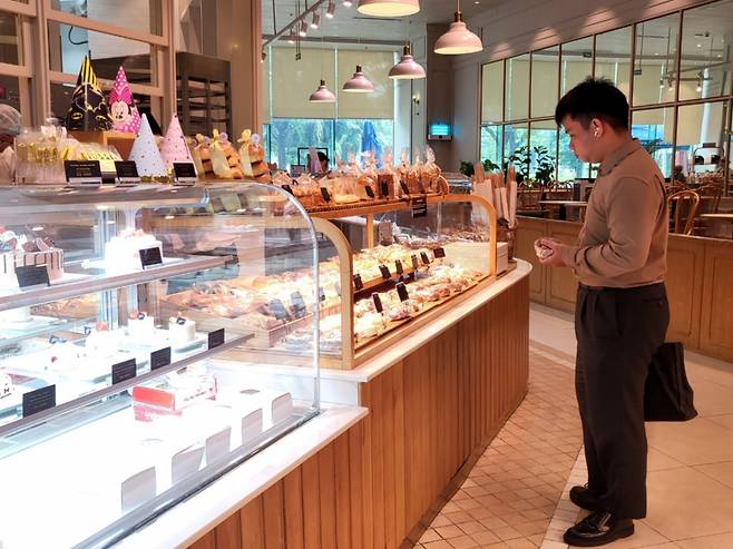 한 고객이 베트남 호치민 크레센트몰에 위치한 파리바게트 매장에서 빵을 고르는 모습./사진=차현아 기자.