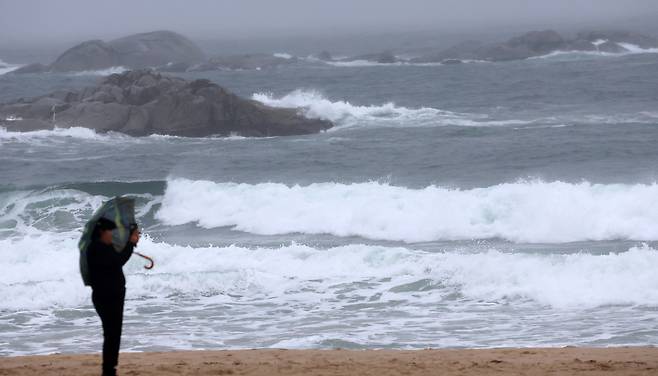 13일 오후 강원 강릉시 경포해수욕장에서 관광객들이 비가 오는 가운데 해변을 걷고 있다.[연합]