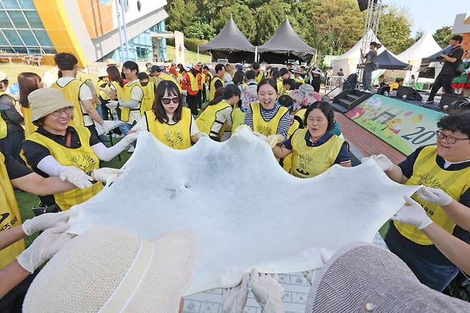 [임실=뉴시스] '2025 임실N치즈축제' 3일째인 10일 임실치즈테마파크를 찾은 관광객들이 체험프로그램에 따라 치즈를 얇게 펼치며 늘리고 있다. (사진=임실군 제공) 2025.10.10. photo@newsis.com  *재판매 및 DB 금지