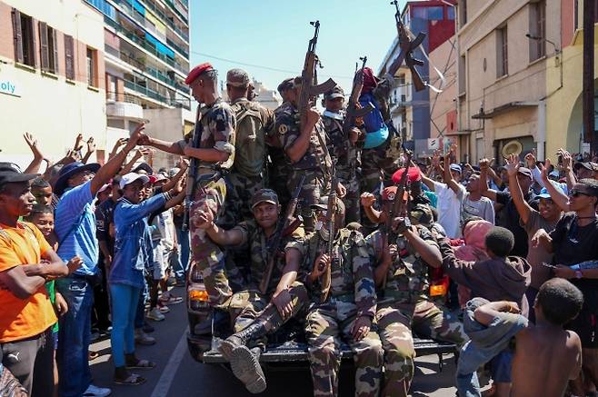12일(현지시간) 아프리카 마다가스카르 수도 안타나나리보에서 반정부 시위 사망자 추모 행사에 참석한 군인들이 시민들의 환영을 받고 있다. 안타나나리보 AP 연합뉴스