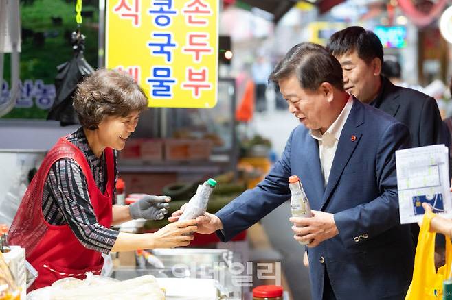 박승원 광명시장이 전통시장에서 지역화폐로 기름을 사고 있다.(사진=광명시)