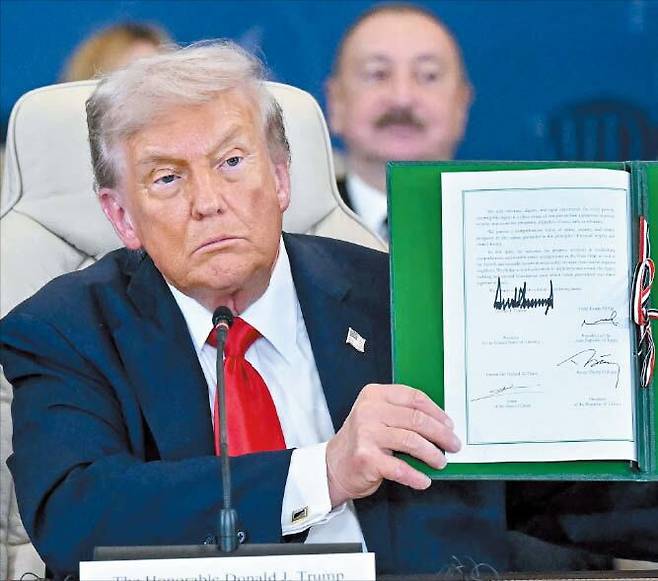 도널드 트럼프 미국 대통령이 13일 이집트 샤름 엘셰이크에서 열린 ‘가자 지구 평화 정착을 위한 정상회의’에서 미국·이집트·카타르·튀르키예가 서명한 합의문을 들어 보이고 있다. /AFP 연합뉴스