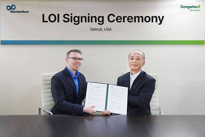 김형남 동화일렉트로라이트 영업본부장(오른쪽)이 매튜 도슨 엘레멘티움 최고경영자 겸 설립자와 포트 폰처트레인 디트로이트 윈덤 호텔에서 열린 신규 전해액 상용화를 위한 업무 협력 의향서 체결식에서 기념 촬영을 하고 있다. 동화기업 제공