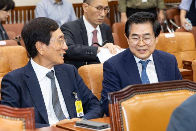 15일 국회 기후에너지환경노동위원회에서 열린 고용노동부 국정감사에 출석한 도세호(오른쪽) SPC 대표와 이배원 한국니토옵티칼 대표가 대화하며 웃고 있다. 뉴스1