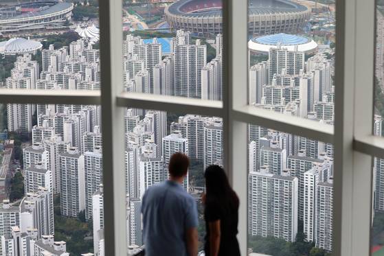 정부가 15일 부동산 관계장관회의를 열고 '주택시장 안정화 대책'을 확정·발표했다.  서울 전역과 분당 과천 등 경기도 12개 지역이 조정대상지역·투기과열지구로 확대 지정되며 토지거래허가구역으로 묶인다. 주택담보대출 한도는 수도권·규제지역의 시가 15억 원 초과~25억 원 이하 주택의 경우 4억 원, 25억 원 초과 주택은 2억 원으로 축소된다.  사진은 이날 서울 송파구 롯데월드타워에서 바라본 아파트 단지. 뉴스1