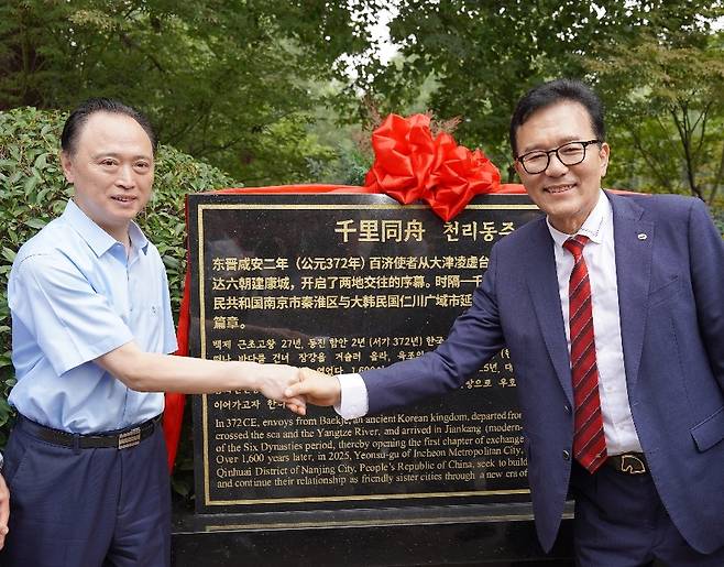 이재호 인천시 연수구청장<우측>이 지난 11일 중국 친화이구 상심성에서 열린 표지석 제막식에서 친화이구 링샹치엔(凌向前) 구장과 악수를 하고 있다.[인천시 연수구 제공]