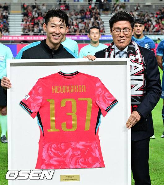 [OSEN=서울월드컵경기장, 조은정 기자]한국 축구가 안방에서 '남미 강호' 파라과이를 물리치며 사상 최초의 2026 국제축구연맹(FIFA) 북중미 월드컵 포트 2 확보에 청신호를 켰다.한국 축구대표팀은 14일 오후 8시 서울월드컵경기장에서 열린 A매치 친선 경기에서 파라과이를 2-0으로 제압했다. 지난 10일 일본 원정에서 2-2로 비기고 온 파라과이는 한국에 덜미를 잡히며 10월 아시아 투어를 1무 1패로 마감하게 됐다.경기 전 차범근 전 감독이 경기장을 찾아 손흥민에게 기념 유니폼을 직접 전달하고 있다. 2025.10.14 /cej@osen.co.kr