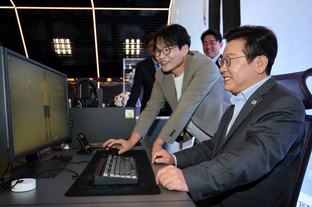 ▲이재명 대통령이 15일 국내 게임사 크래프톤의 게임·문화 플랫폼 서울 성동구 '펍지 성수'에서 AI기반 인생 시뮬레이션 게임 '인조이'를 체험하고 있다. 옆은 김형준 인조이스튜디오 대표. ⓒ연합뉴스
