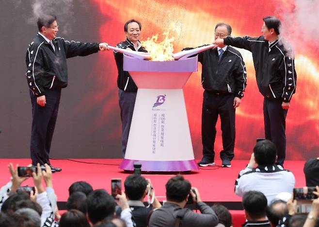 13일 오전 부산 연제구 시청 시민광장에서 열린 제106회 전국체육대회와 제45회 전국장애인체육대회 성화 합화 및 출발식 행사에서 박형준 부산시장(맨 오른쪽)과 안성민 시의회 의장, 김석준 시 교육감, 장인화 시 체육회장이 4곳에서 채화된 불꽃을 합화하고 있다. 사진=연합뉴스