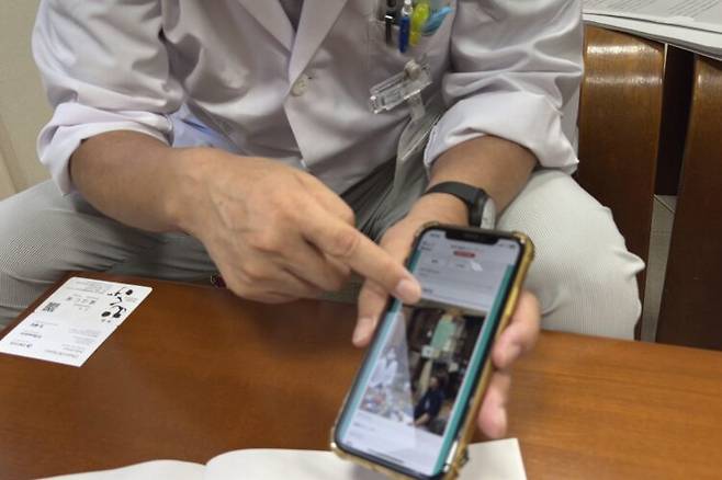 재택 진료 앱에 대해 설명하는 고다 마사히코 히노병원 원장. 간호사가 환자 집을 방문했을 때 스마트폰으로 상황을 촬영해 의사에게 전송하면, 의사가 즉시 대응 방법을 지시한다. 앱 화면에는 환자의 집 모습과 실시간 지시 사항이 기록돼 있었다. 사진=천옥현 기자