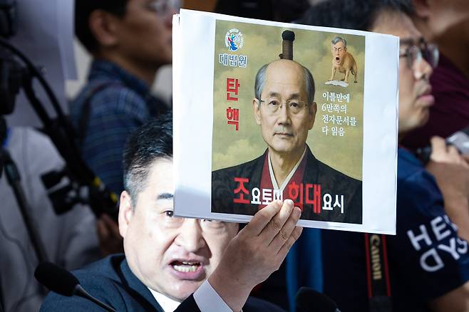 최혁진 무소속 의원이 13일 서울 여의도 국회에서 열린 법제사법위원회의 대법원 등에 대한 국정감사에서 조희대 대법원장에게 질의하며 손팻말을 들어보이고 있다./뉴스1