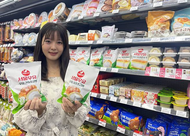 모델이 GS25의 '서울우유 소금크림빵'을 들고 포즈를 취하고 있다.