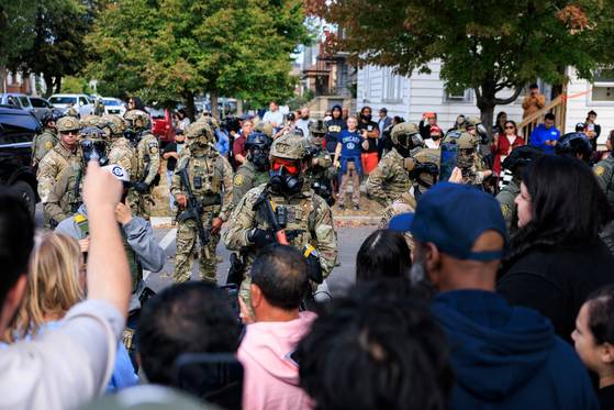 14일(현지시간) 미국 시카고에서 ICE 요원들이 시위대를 막고 서 있다. AP=연합뉴스