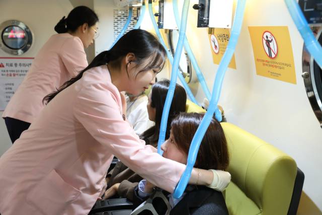 한강성심병원 고압산소치료센터 의료진(왼쪽)이 기자에게 마스크 착용 법을 설명하고 있다. 사진 제공=한강성심병원