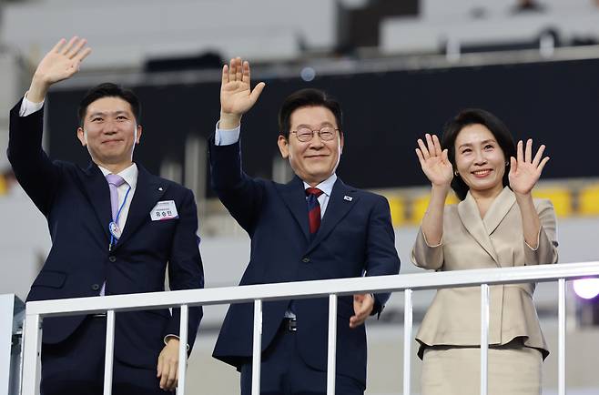 이재명 대통령과 김혜경 여사가 17일 부산 아시아드주경기장에서 열린 제106회 전국체육대회 개회식에서 입장하는 선수단을 향해 손을 흔들고 있다. 왼쪽은 유승민 대한체육회장. <저작권자(c) 연합뉴스, 무단 전재-재배포, AI 학습 및 활용 금지>
