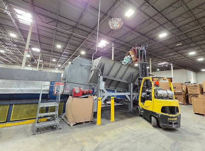 작업자가 분류된 전자폐기물들을 대형 파쇄기 투입구에 투입하고 있다. ⓒ데일리안 정진주 기자