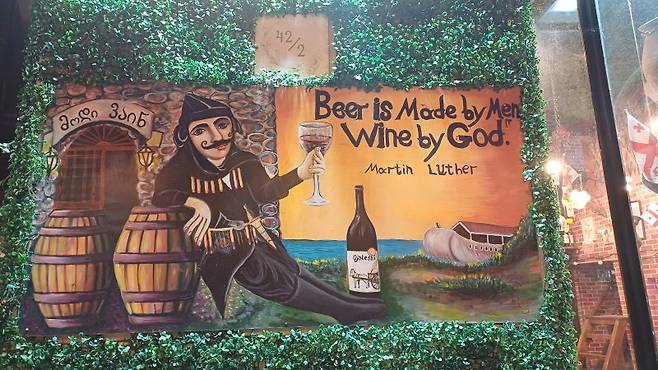 "사람은 맥주를 만들었고, 신은 와인을 만들었다"는 내용의 조지아 와인 샵 벽화사진=이환주 기자
