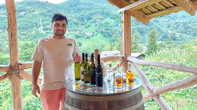 조지아 '치하밸리 와이너리'를 운영하는 다비트 비비네이슈빌리씨가 유기농으로 생산한 와인과 증류주를 선보이고 있다. 사진=이환주 기자