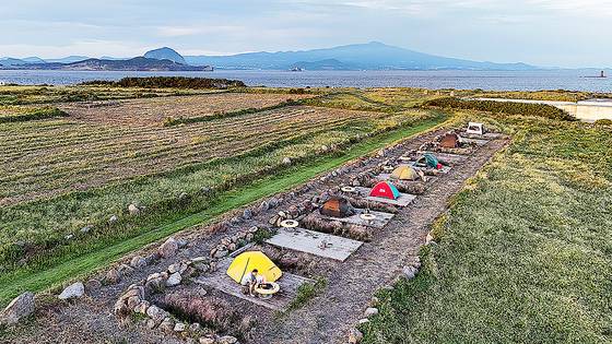 가파도 야트막한 언덕 밭에 조성한 태봉왓캠핑장. 백패커 사이에서 이름난 캠핑 명당이다. 바다 건너 펼쳐진 한라산의 모습이 일품이다. 주변에 시야를 막는 높은 산이 없어 일출과 일몰을 모두 감상할 수 있다.