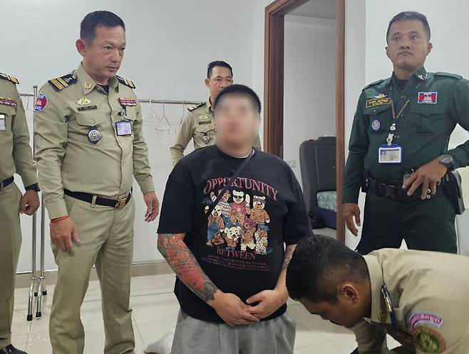 김병주 더불어민주당 의원은 18일 캄보디아 수도 프놈펜에 감금됐던 정모씨 등 한국 청년 3명을 구출했다고 밝혔다. 본지는 캄보디아 경찰이 정씨를 구출하던 당시 사진을 입수했다. 무릎을 꿇고 있는 인물이 정씨. /독자 제공