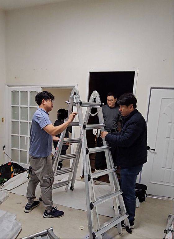 도배사들이 한 구축 주택 현장에서 작업하고 있다. [중앙포토]