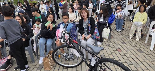 자전거 경품을 탄 또 다른 가족들이 즐거운 표정을 지어 보이고 있다.