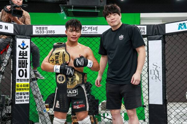 아마추어 종합격투기 단체 KMMA 더블 챔피언에 등극한 이현우(왼쪽)가 김대환 KMMA 대표이사와 함께 기념촬영을 하고 있다. 사진=KMMA
