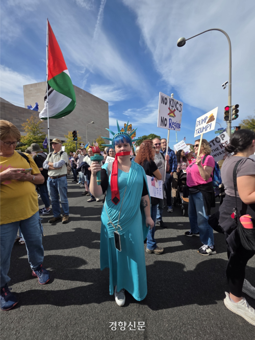 표현의 자유를 억압당하고 있다는 뜻으로 입에 재갈이 물린 ‘자유의 여신상’ 복장을 하고 나온 시민. 뒤에 팔레스타인 국기가 나부끼고 있다.