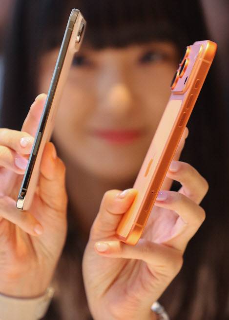 한 여성이 역대 가장 얇은 아이폰 에어(왼쪽)와 아이폰17 PRO를 들어 얇기를 비교하고 있다. [사진, 연합]