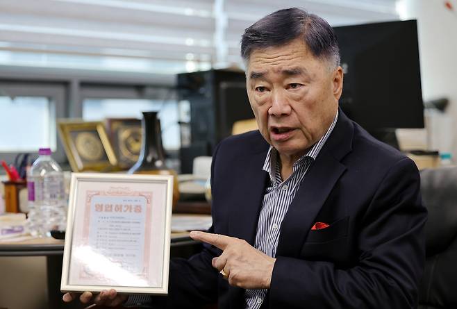 정양근 민간남북교류협의회 회장이 인터뷰 중&nbsp;북측 민족경제협력련합회로부터 받은 영업허가증을 들어 보이고 있다. 이재문 기자
