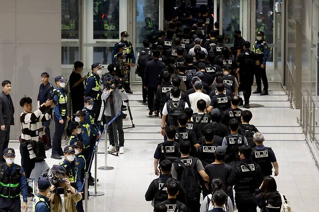 캄보디아 온라인 사기에 가담해 구금된 한국인들이 18일 오전 인천국제공항 제2터미널을 통해 송환되고 있다. 이날 송환에는 경찰 호송조 190여명이 투입됐다. [연합]