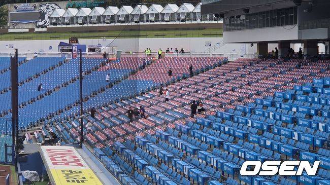 [OSEN=대구, 한용섭 기자] 한화 이글스 관계자들이 21일 플레이오프 3차전이 열리는 대구 삼성라이온즈파크 1루측 관중석에 오렌지색 우비와 오렌지색 수건을 배포하고 있다. /orange@osen.co.k