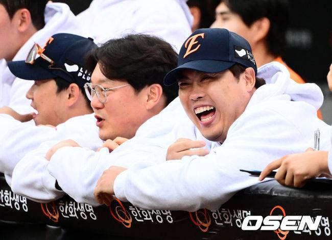 [OSEN=대전, 지형준 기자] 프로야구 한화 이글스가 첫 판을 승리하고, 한국시리즈 진출 확률 76.5%를 잡았다.&nbsp;한화는&nbsp;18일 대전 한화생명볼파크에서 열린 2025 KBO리그 플레이오프(5전 3선승제) 1차전 삼성 라이온즈와 경기에서 9-8&nbsp;재역전 승리를 거뒀다.&nbsp;예상과 달리 난타전이었고, 한화는 15안타를 몰아쳤다.&nbsp;선발 폰세는 6이닝 7피안타(1피홈런) 1볼넷 8탈삼진 6실점(5자책)으로 부진했으나 승리 투수가 됐다. 문동주가 7회 구원투수로 등판해 2이닝 1피안타 4탈삼진 무실점으로 잘 던졌다. 마무리 김서현은 9회 등판해 홈런 등 2점을 허용하고 교체됐다. 김범수가 세이브를 기록했다.&nbsp;한화 류현진이 더그아웃에서 경기를 지켜보며 미소짓고 있다. 2025.10.18 /jpnews@osen.co.kr