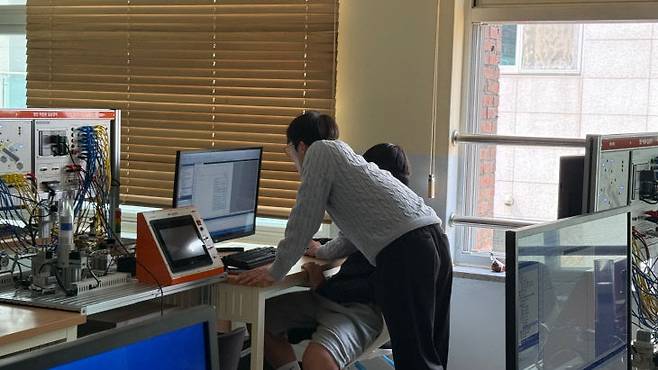 전기과 학생들이 PLC 프로그래밍 실습을 하고 있다.