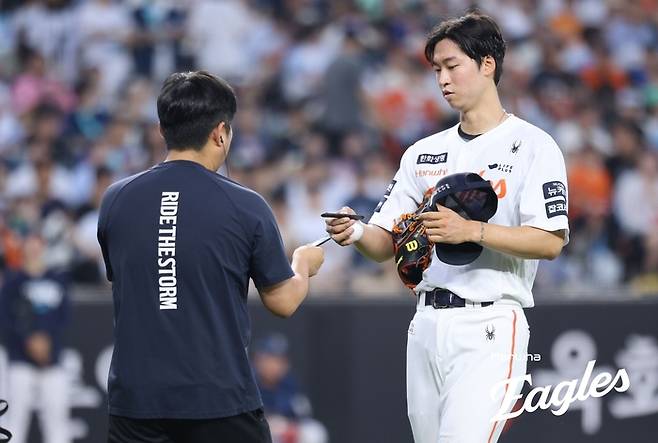 엄상백이 피치컴 기기를 건네 받는 모습. 사진 | 한화 이글스