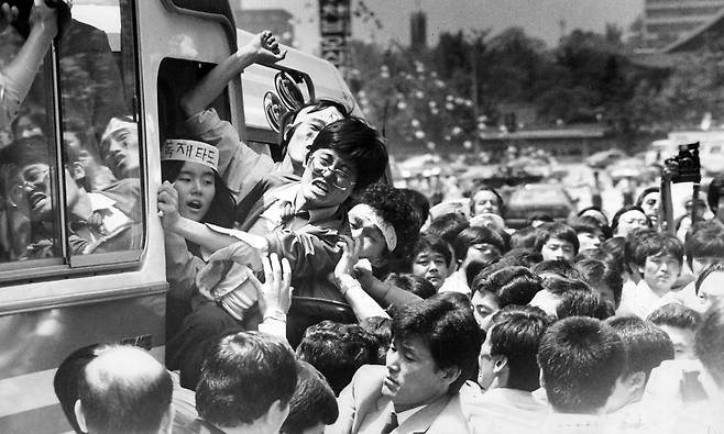 1985년 5월 서울 미국문화원 점거를 주도했던 함운경(가운데 안경쓴 이)이 72시간 만에 농성을 끝낸 뒤 경찰 버스에 오르며 구호를 외치고 있다. 사건 직후 점거 참여 73명 중 함운경(서울대),신정훈(고려대),이정훈(고려대) 등 25명이 구속됐고, 김민석(서울대),허인회(고려대),박선원(연세대),고진화(성균관대) 등 10여 명은 배후 명목으로 수배됐다. /조선일보 DB