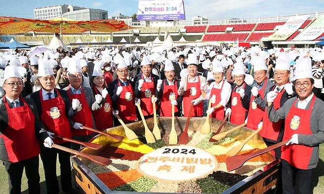 지난해 전주비빔밥축제 개막식에서 주요 인사들이 대형 비빔 퍼포먼스를 진행하며 성공 개최를 기원하는 파이팅을 외치고 있다. 전주시 제공