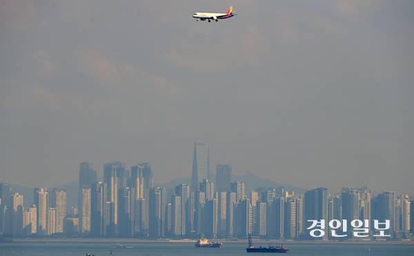 23일 오후 인천시 중구 무의도에서 항공기가 송도국제도시를 배경으로 인천공항에 착륙하고 있다. 2025.10.23 /조재현기자 jhc@kyeongin.com
