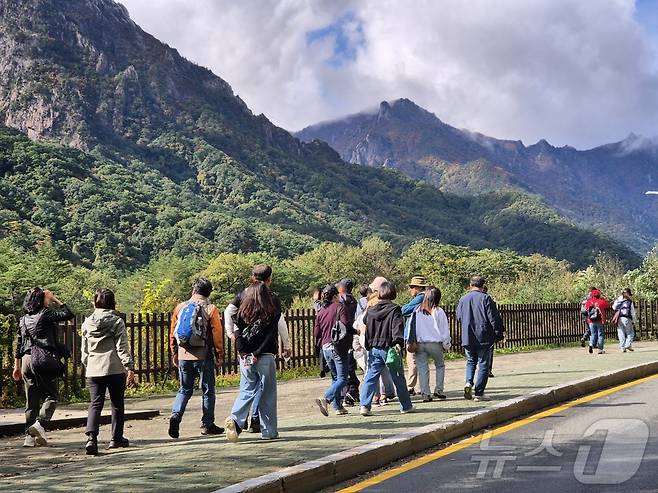 23일 강원 속초시 설악산국립공원 입구에서 탐방객들이 줄지어 들어서며 절정의 단풍을 만끽하고 있다. 202510.23/뉴스1 2025.10.23/뉴스1 ⓒ News1 윤왕근 기자