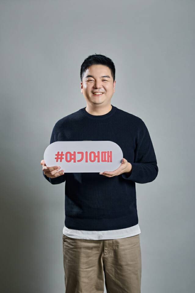 조민석 여기어때 D&A 센터장이 여기어때 판넬을 들고 사진을 찍고 있다. (사진=여기어때)