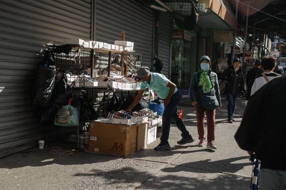 지난 22일(현지시간) 미국 뉴욕에서 이민 단속 작전이 벌어진 뒤 노점상이 상품을 정리하고 있다. AP=연합뉴스