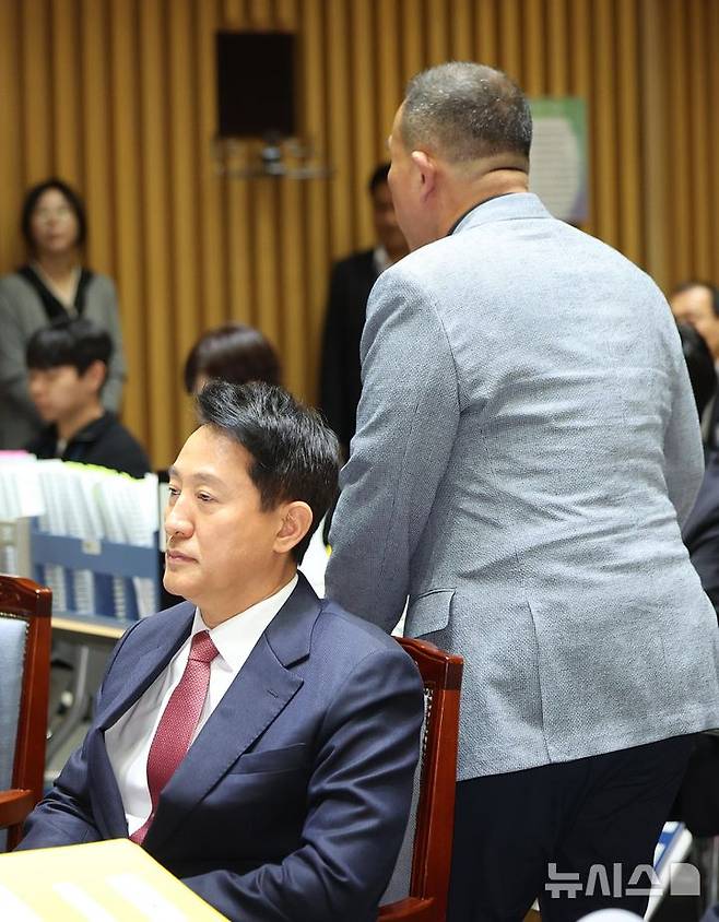 [서울=뉴시스] 김선웅 기자 = '정치브로커'로 알려진 명태균 씨가 23일 서울시청에서 열린 국회 행정안전위원회의 서울특별시에 대한 국정감사에 증인으로 출석해 발언대로 이동하고 있다. 왼쪽은 오세훈 서울시장. 2025.10.23. mangusta@newsis.com