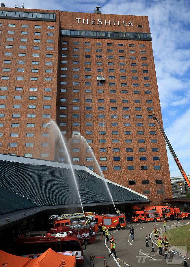 24일 오전 서울 중구 신라호텔에서 열린 '2025 중구 안전한국훈련'에서 소방대원들이 소방차를 이용해 화재를 진압하는 훈련을 하고 있다. 2025.10.24/뉴스1 ⓒ News1 김진환 기자