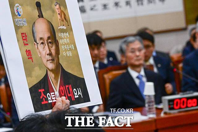 반환점을 돈 국정감사가 혹독한 평가를 마주했다. 행정부 감시 기능이 사실상 실종됐다는 비판이 나온다. 사진은 최혁진 무소속 의원이 지난 13일 오전 서울 여의도 국회 법제사법위원회 국정감사에서 조희대 대법원장(오른쪽)을 향해 항의 피켓을 들고 있는 모습. /남윤호 기자