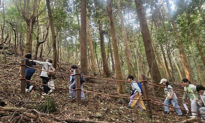 올 3월 제주시 구좌읍 송당초등학교 3, 4학년 학생들이 학교 인근 당오름을 오르고 있다. 송당초는 학교 특색 과목인 ‘송당과 신화’를 운영한다. 송당초 학생들은 매년 제주 신화를 배우고 생태해설사와 함께 오름을 직접 오르며 자연환경을 탐방한다. 송당초 제공