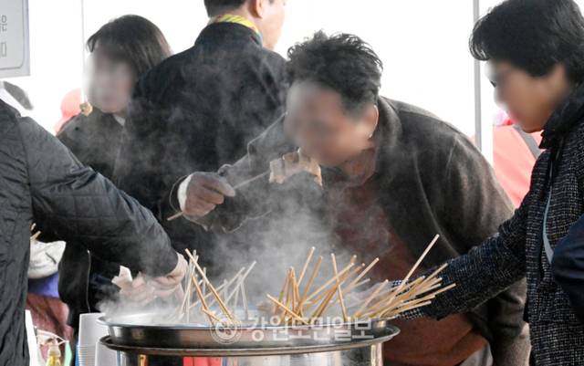 ▲ 강원지역이 쌀쌀한 날씨를 보인 지난 22일 춘천 풍물시장에서 시민들이 따뜻한 오뎅을 먹으며 추위를 녹이고 있다. 김정호 기자