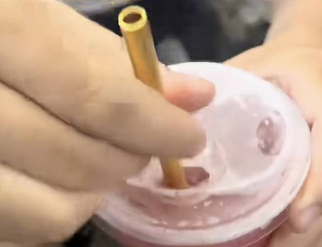 서우씨가 밀크티에 금 빨대를 꽂는 모습. 더우인