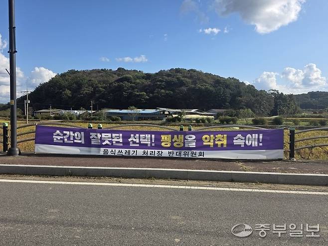 미산면 백석리 인근 도로에 '순간의 잘못된 선택! 평생을 악취 속에!'라는 문구의 반대 현수막이 게시돼 있다. 사진=이석중기자