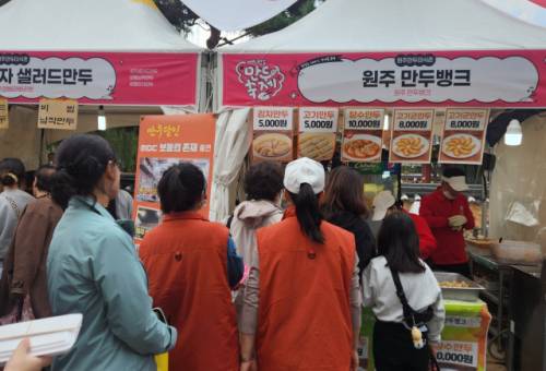 ◇제3회 원주만두축제를 찾은 중국 단체 관광객들이 만두를 사기 위해 줄서있다.